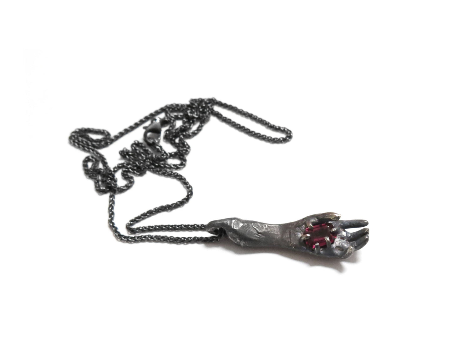 HAND HOLDING RHODOLITE GARNET