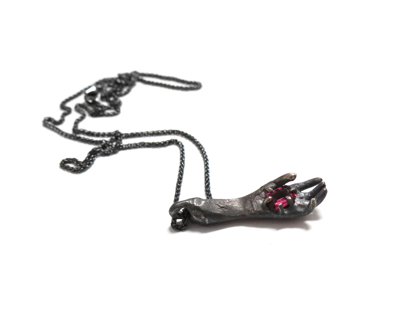 HAND HOLDING RHODOLITE GARNET