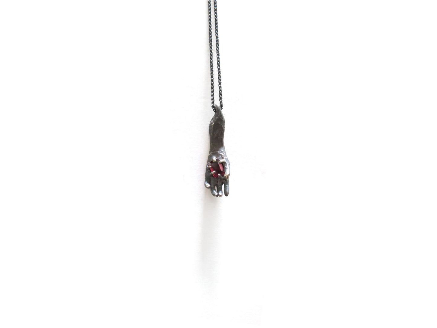 HAND HOLDING RHODOLITE GARNET