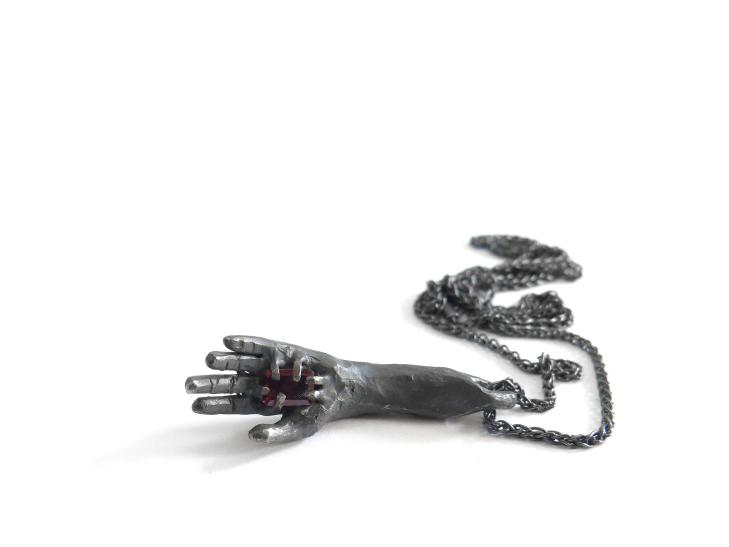 HAND HOLDING RECTANGULAR RHODOLITE GARNET