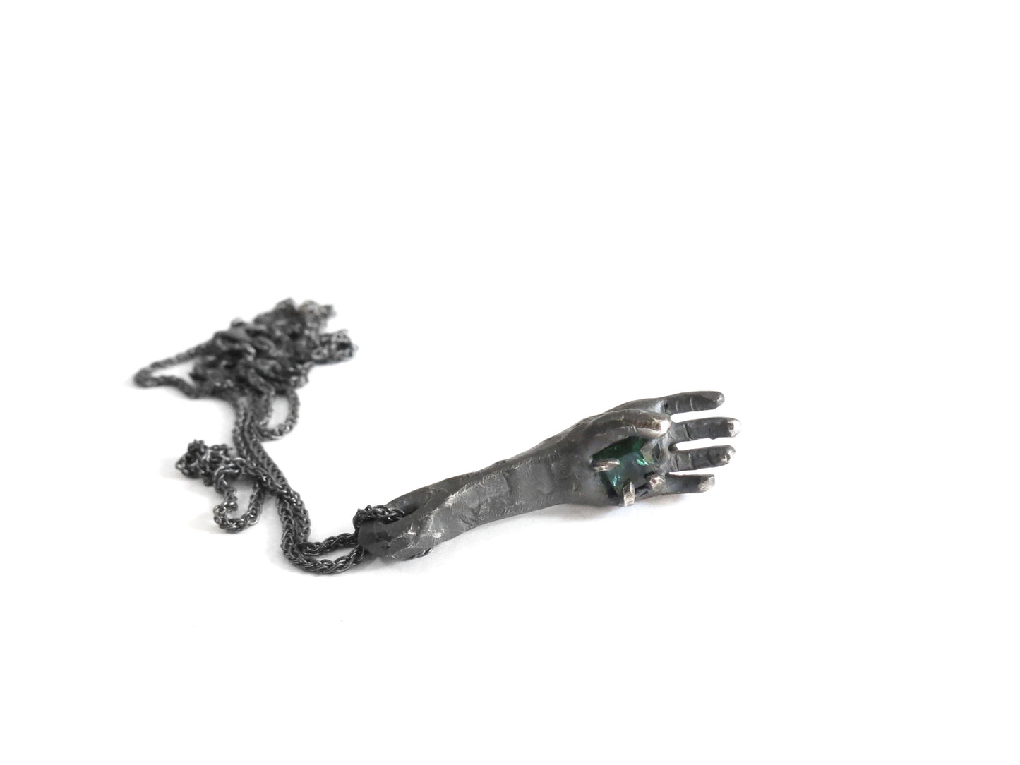 HAND HOLDING DARK GREEN TOURMALINE