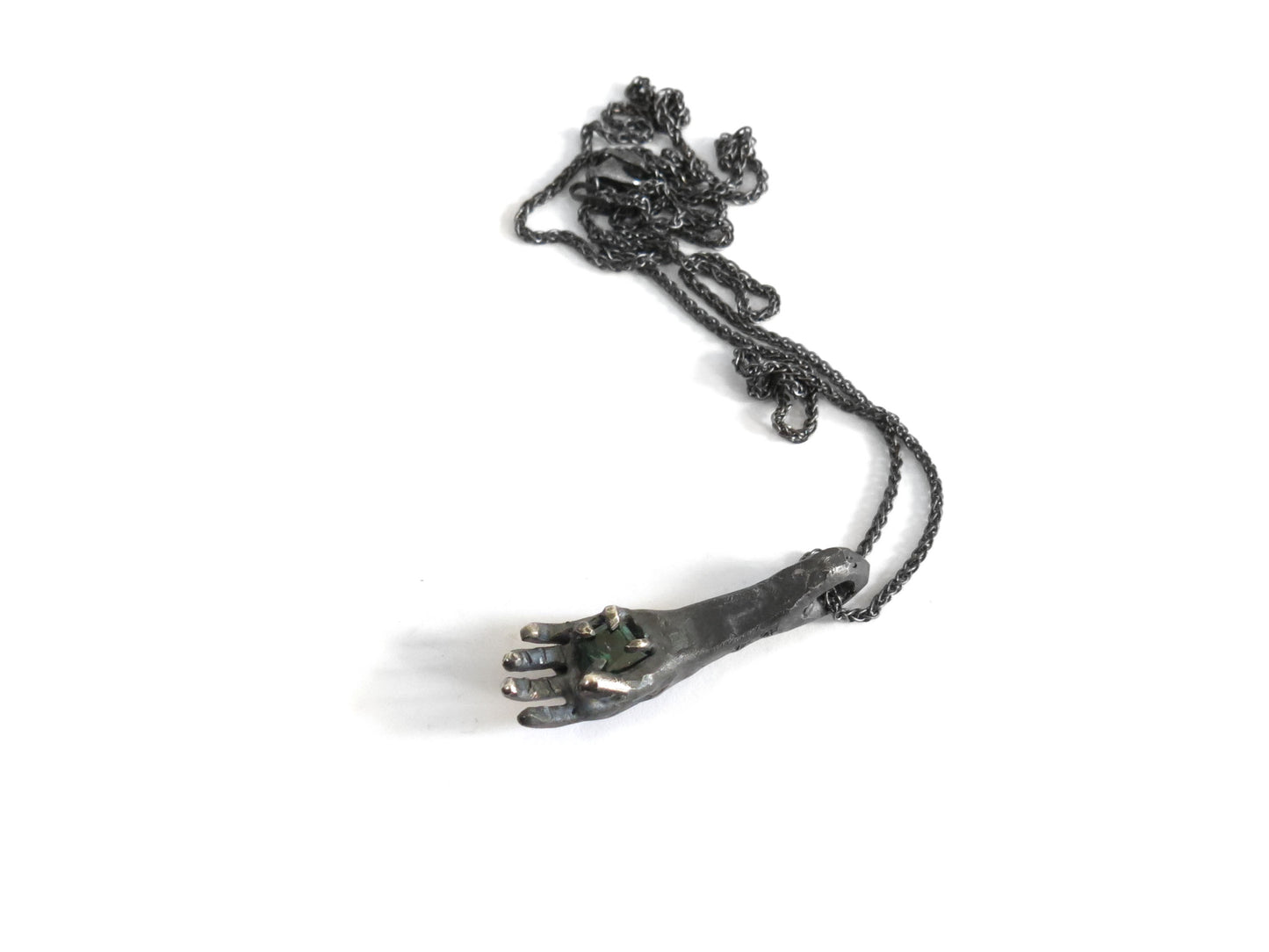 HAND HOLDING DARK GREEN TOURMALINE