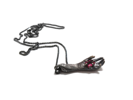 HAND HOLDING RHODOLITE GARNET