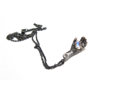 HAND HOLDING RAINBOW MOONSTONE