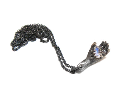 HAND HOLDING RAINBOW MOONSTONE