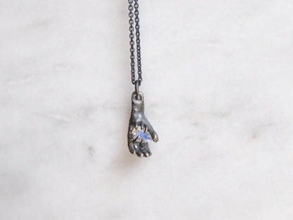 HAND HOLDING RAINBOW MOONSTONE